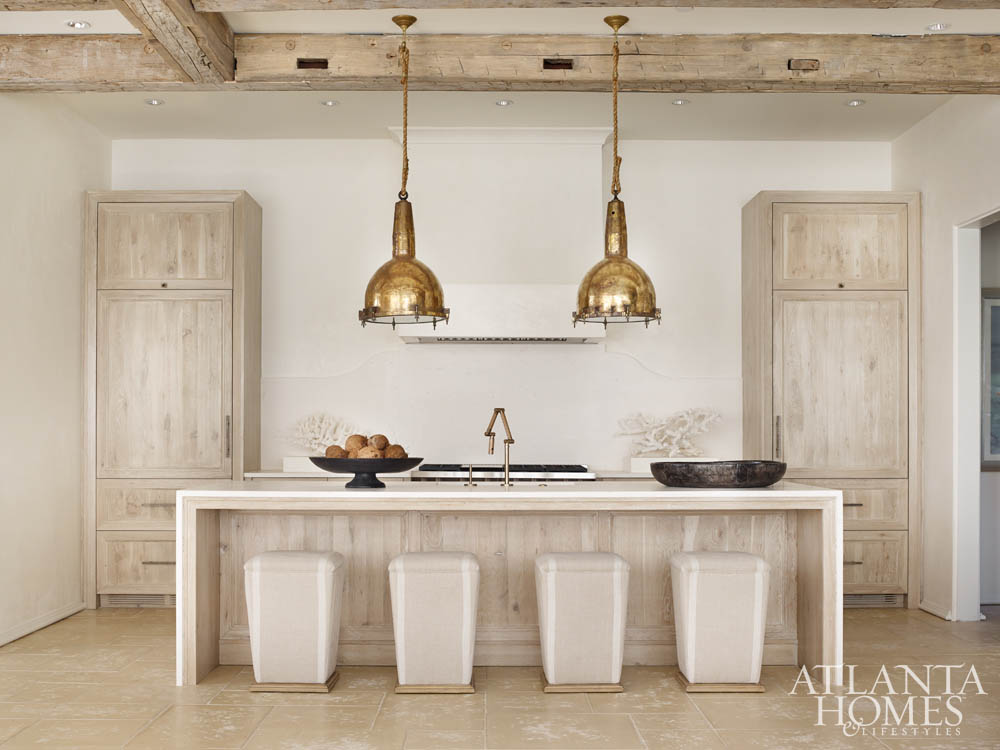Warm and modern minimal design in kitchen with oversized brass pendants