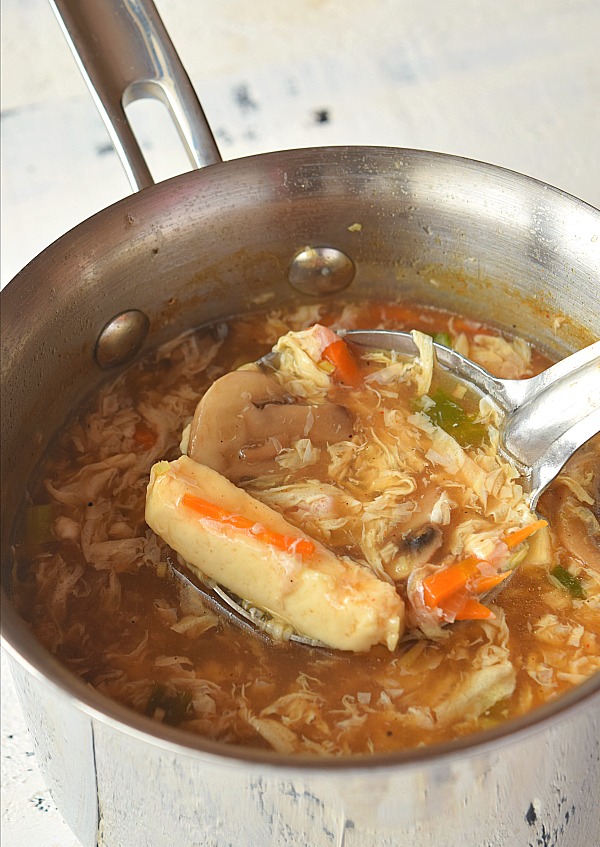 A ssauce pan with hot and sour soup with tofu,mushrooms and egg ribbons