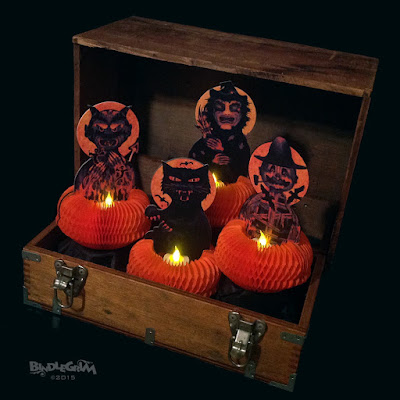 Using battery-operated tealights, the Beasties (witch, scarecrow, devil, and black cat) are shown here lighting up an old crate in the dark.