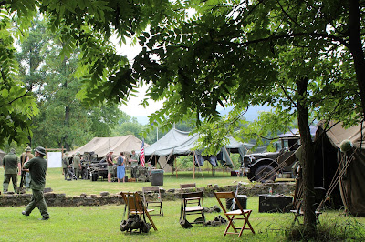 Vietnam era military encampment with tents and jeep, people in uniform Vietnam era military encampment with tents and jeep, people in uniform