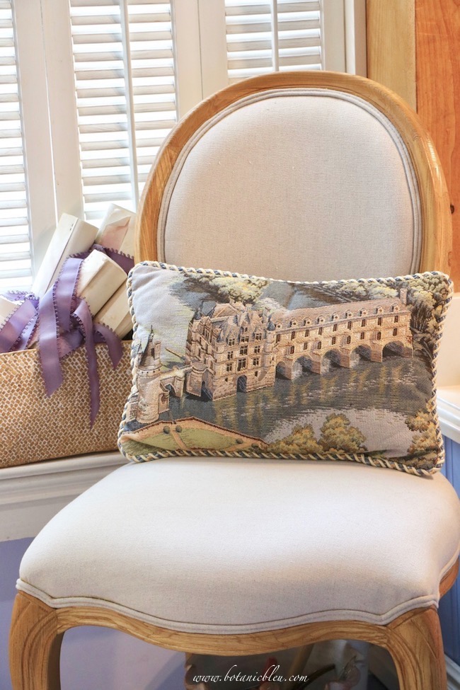 needlepoint pillow of chenonceau adds french country style to master bathroom