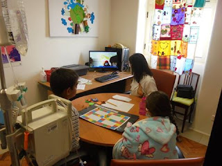 Alunos e professora a olhar para ecrã (TeleAula - sessão de videoconferência)