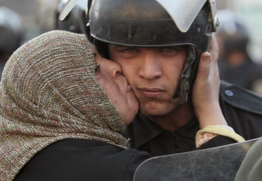 35 moments of violence that brought out incredible human compassion - egyptian woman kisses a policeman during the revolution