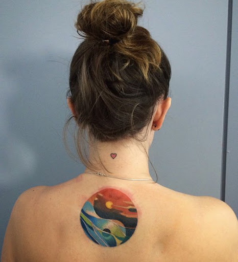 Colorido Yin Yang tatuagem nas costas. Este símbolo do Yin Yang brinca com o fogo e a água, elementos e incorpora-los para a tatuagem.
