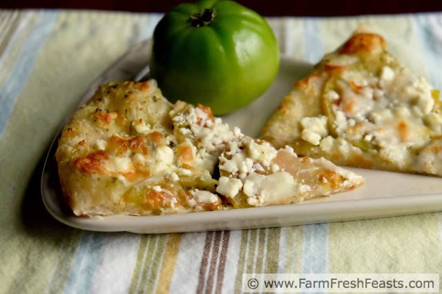 a slice of green tomato pizza topped with pesto and feta cheese