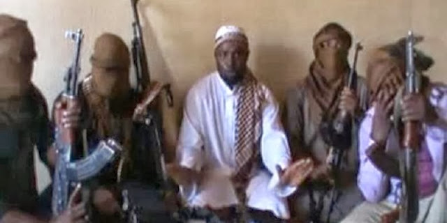  Pemimpin Boko Haram Abubakar Shekau (tengah) dan para anggota militan. Tersangka militan Boko Haram menewaskan 19 orang hari Minggu (20/10). | AFP