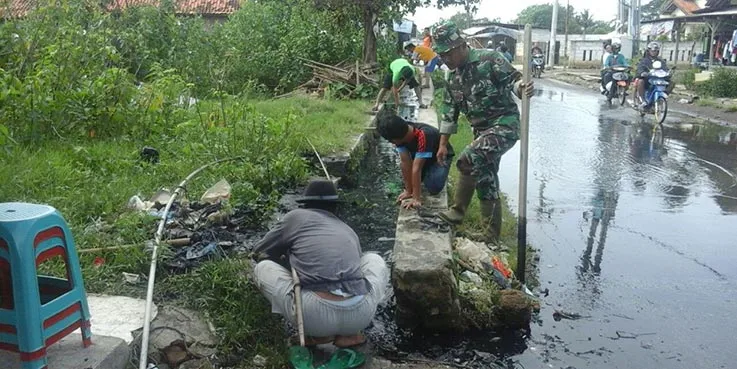 Mereka yang sedang membersihkan saluran air dari sampah dan lumpur.