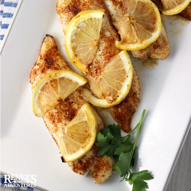 Cajun Baked Tilapia Loins by Renee's Kitchen Adventures on a white platter with parsley and lemon