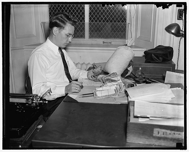 Checking over confiscated counterfeit currency at the Secret Service Div. of the Treasury, 10/38