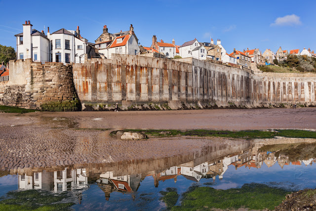 Reflection of the pretty village of Robins Hood's Bay in North Yorkshire by Martyn Ferry Photography