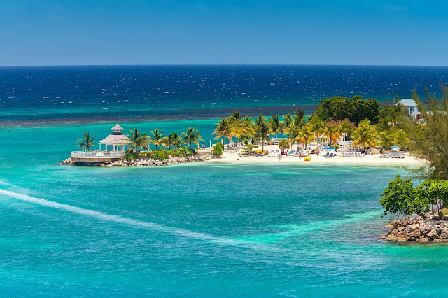 Plage d'Ocho Rios pour des vacances en Jamaique : sable fin, cocotierset chaises longues sur le rivage