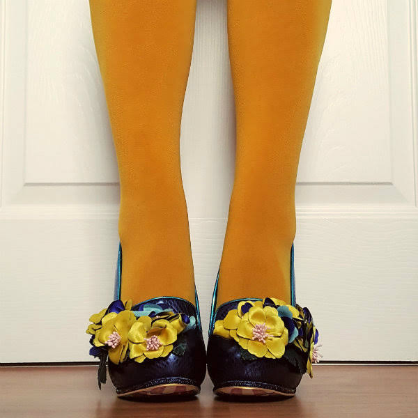Irregular Choice Ember Starwand front feet facing forward with yellow tights and blue shoes with large flowers on them