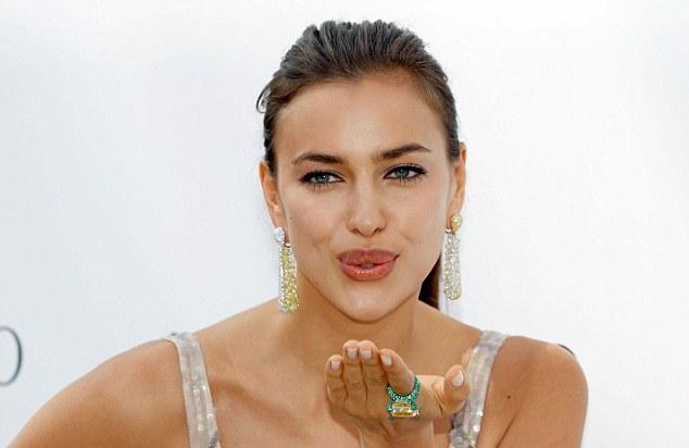 Irina Shayk blows a kiss to photographers as she arrives at Cannes