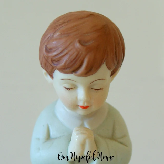 porcelain little boy brown hair blue suit red lips praying