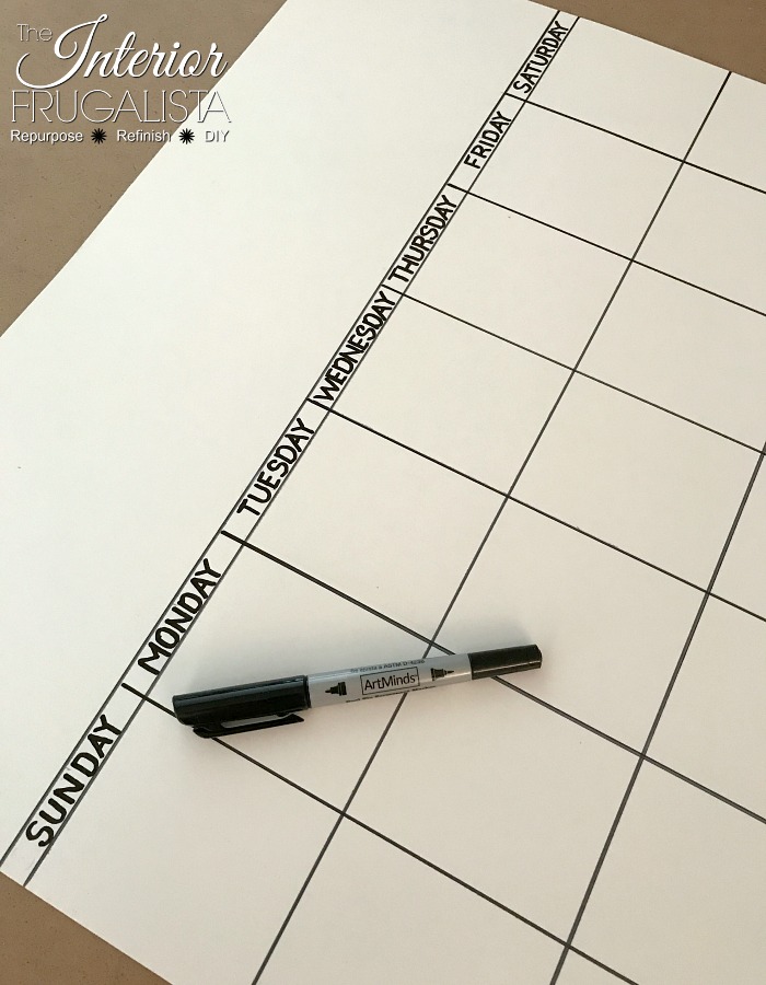 Drawing a grid on white bristol board for a DIY dry erase wall calendar made with old windows.