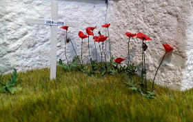 One-twelfth scale miniature poppies and crosses planted in a lawn.