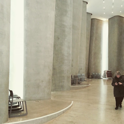 The interior of a modern building made with undulating concrete.