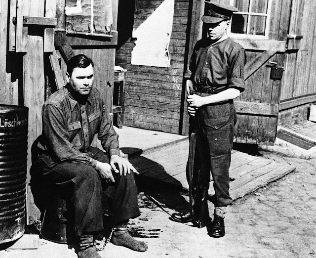 Manacled following his arrest is Joseph Kramer, commandant of the Bergen-Belsen concentration camp in Belsen, photographed on April 28, 1945. After standing trial, Kramer,