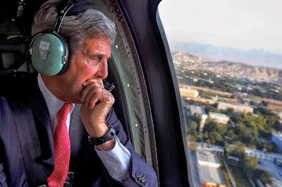 US Secretary of State, John Kerry looks out of the window of a Black Hawk helicopter at the city en route to ISAF Headquarters after an unannounced visit to meet with Afghan President Hamid Karzai, in Kabul on October 11, 2013.  US Secretary of State John Kerry arrived on an unannounced visit to Kabul to try to advance troubled negotiations with Afghanistan on some US troops staying in the country after 2014