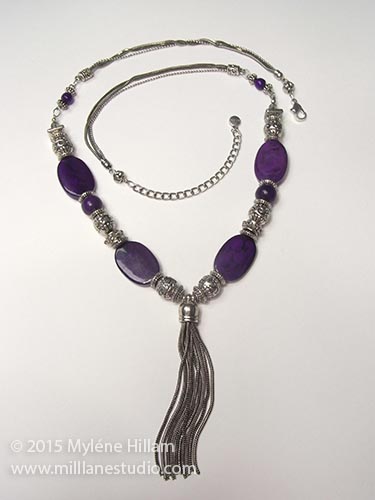 Purple and antiqued silver necklace with a chain tassel. 