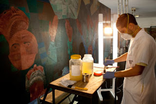 Restaurador trabalhando na restauração de um dos paineis "Guerra e Paz", de Portinari