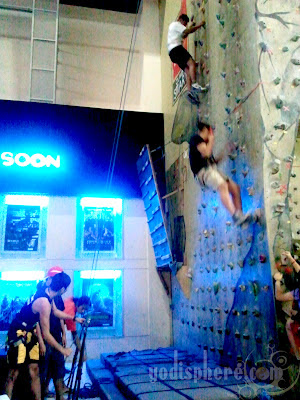 People handling the belays while two people are climbing walls 