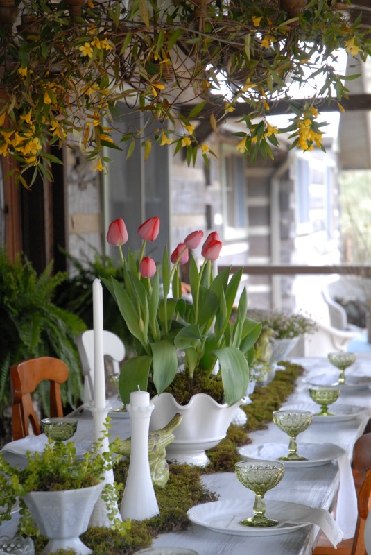 A Gathered Vintage Spring | Porch tablescape. Yellow Jasmine hanging on outdoor chandelier, moss runner, pink tulips, vintage green depression glass, and vintage milk glass.