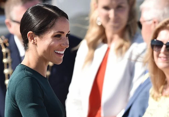 Meghan Markle wore Givenchy patch pocket pencil skirt, and Vanessa Tugendhaft Charm earrings, carried Strathberry handbag