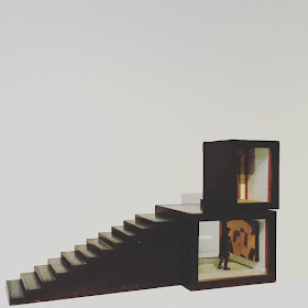 Assemblage art piece by Alex Asch, with two black boxes and a staircase.
