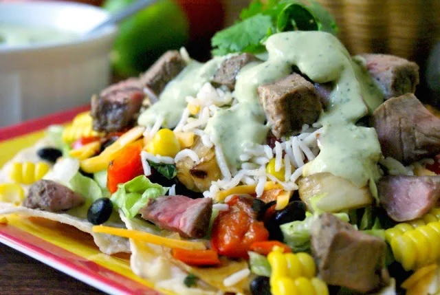 A fresh, healthy and delicious Taco Salad topped with Cilantro Lime Rice, grilled veggies and sirloin steak.