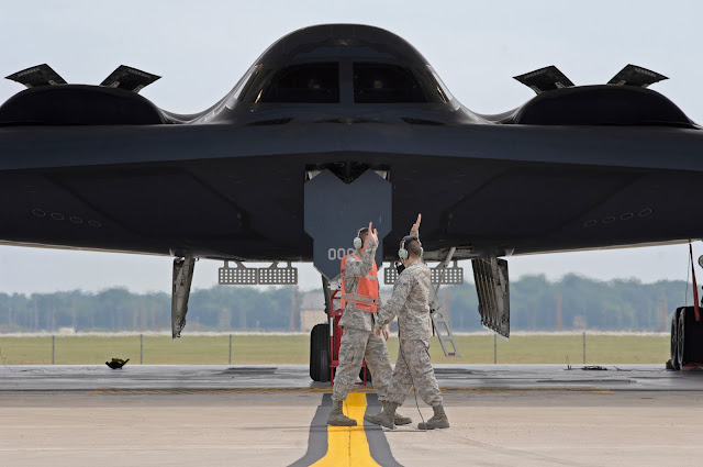 Two airmen  start the high-five salute as they prepare to launch the first B-2 Spirit