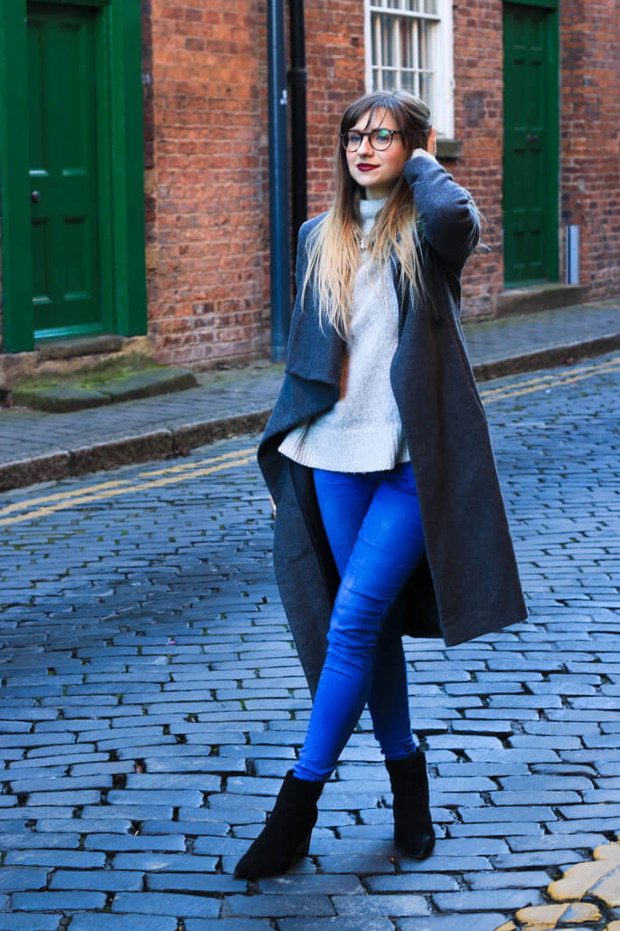 Winter fashion girl in long grey coat and jeans