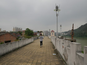 man jogging on a wall bordering the Gui River (桂江) in Wuzhou (梧州)