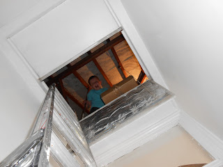 aluminium ladder to loft hatch boy in attic retrieving cardboard storage boxes