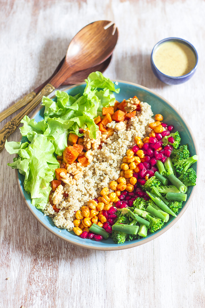 roasted sweet potato, chickpea, quinoa salad with walnuts, pomegranate, broccoli and beans in a mustard date dressing