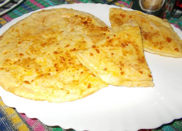 Pão de queijo de frigideira, um com recheio e o outro sem recheio Pão de queijo de frigideira recheado com queijo