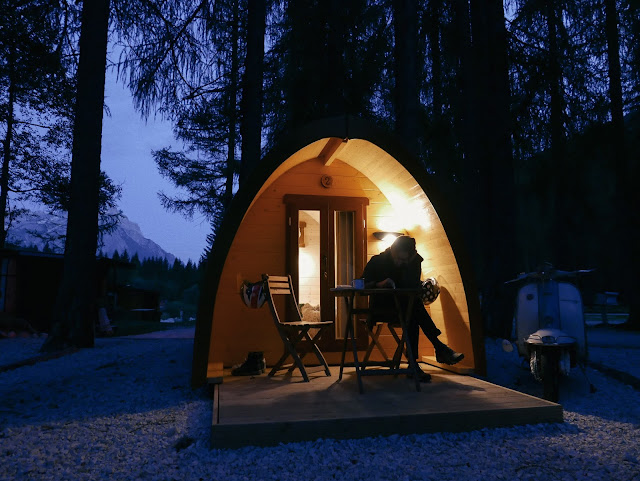 glamping in Cortina d'Ampezzo: our lambretta parked outside a charming wooden tent.
