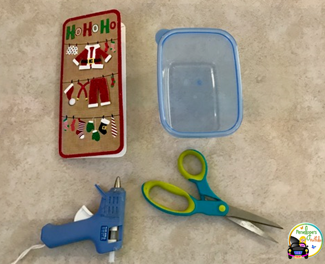 The Best Life-Size Advent Calendar A holiday greeting card, an empty plastic container, a glue gun, and scissors