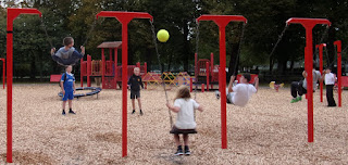 throwing a yellow football at kids on a swing playpark swing activity