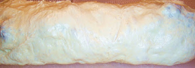 this is a pizza dough with a filling of Antipasto ingredients. there are tomatoes, escarole, salami, mortadella, hot capicola and imported Italian cheeses in this roll baked and this is sliced to show what the filling looks like inside