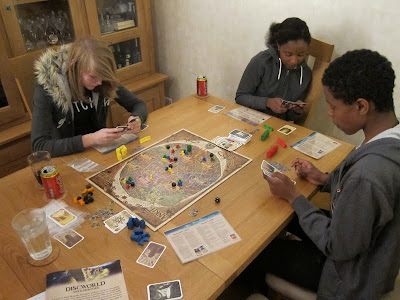 Discworld: Ankh-Morpork - The players consider what cards they wish to play next