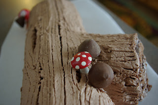 Log cake (Buche de Noel) with bark frosting, candy mushrooms, and edible moss