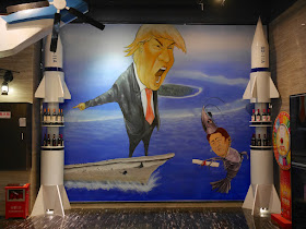mural of Donald Trump pointing from a ship and Shinzo Abe made to look like a shrimp