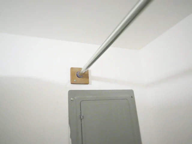 pallet wood scrap holding up shower rod in laundry room