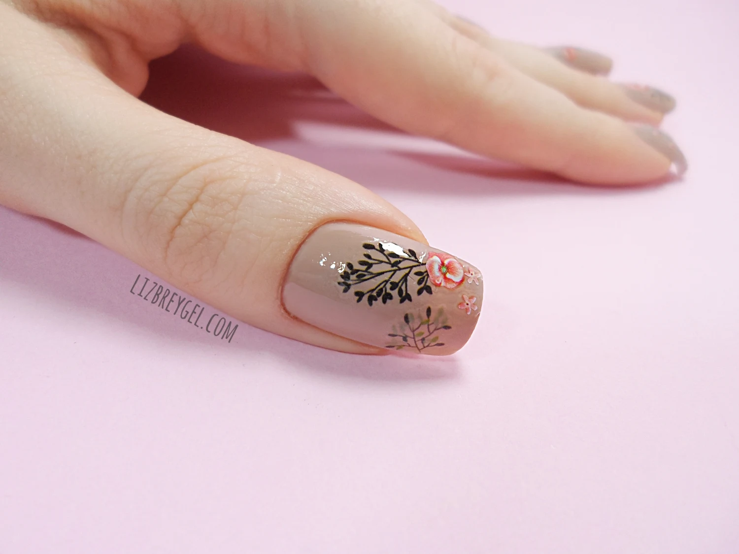 close-up of floral nail stickers on rosy background