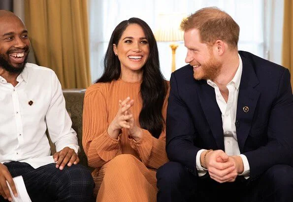 Meghan Markle wore Preen by Thornton Bregazzi Glenda asymmetric plissé georgette midi dress. Prince Harry