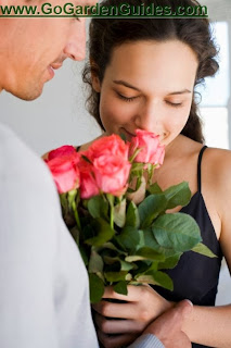 Photo of a Woman in Bra Smelling Bouquet of Roses