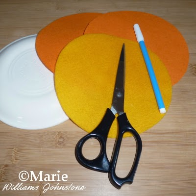 Plate, 3 cut circles of felt fabric, fabric marker and scissors