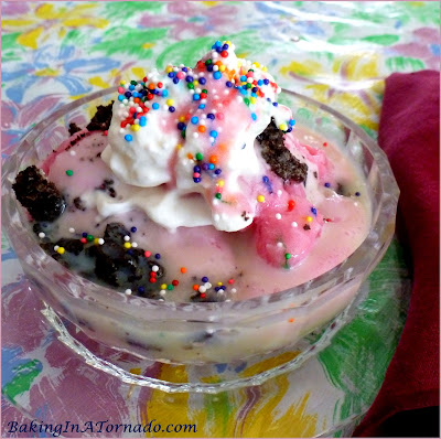 White Chocolate Oreo Raspberry Sundae, a refreshing summer dessert. Raspberry Sherbet topped with crushed oreos and a hot white chocolate sauce | Recipe developed by www.BakingInATornado.com | #recipe #dessert