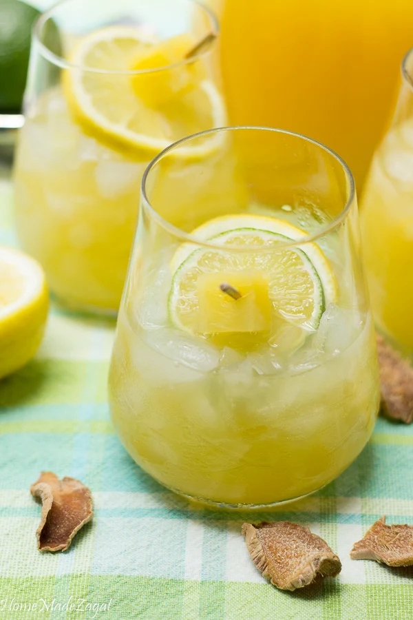 A pic of a full glass of ginger pineapple lemonade with ginger slices